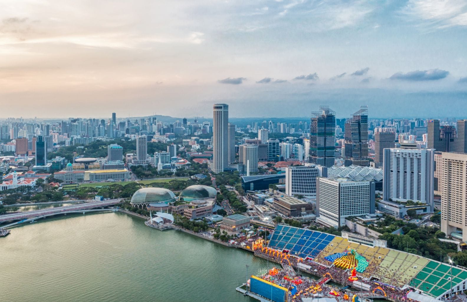 Panoramic view of Singapore harbor at dusk, showcasing Marina Bay Sands and the city skyline – a prime example of the luxury lifestyle attracting HNWI relocation to Singapore.